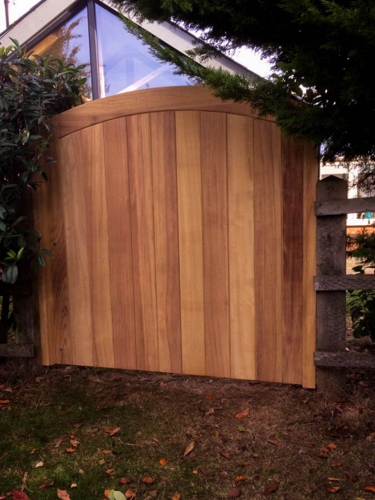 Curved Top Exterior Iroko Gate with no treatment, left to weather silvery-grey