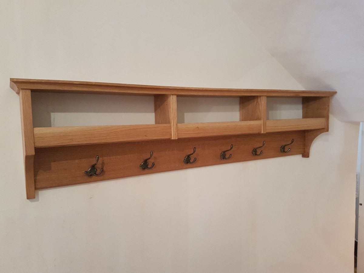 Wall mounted bespoke oak coat rack with hat and glove storage with antique metal coat hooks bespoke joinery hertfordshire