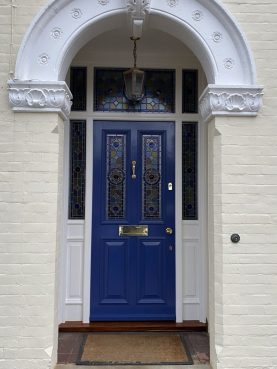 Hardwood front door with side apnels and top lights with decorative leaded lights outside